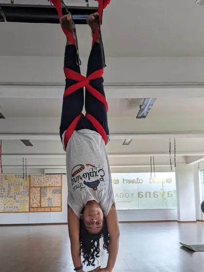 A student works on her supported inversion, building strength and confidence in our weekend aerial class.