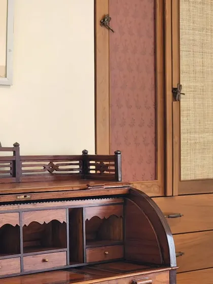 An antique roll-top desk paired with a custom-built wardrobe. We often integrate clients' existing furniture into our designs, creating a layered space that feels collected and personal over time.