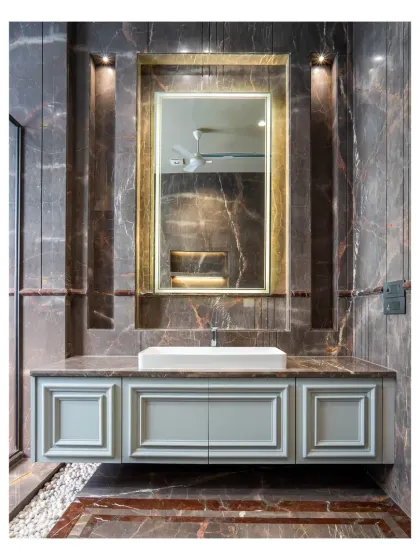 A close-up of the vanity in the dark marble bathroom. The neo-classical style of the cabinet doors contrasts beautifully with the modern vessel sink and the dramatic, veined marble.