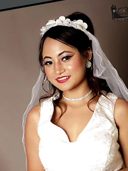 A happy bridal portrait of a model in a white gown and veil, with a simple yet elegant floral tiara.