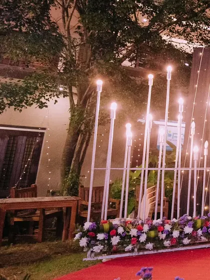 Modern lighting fixtures combined with a floral base on a red carpet. This shows how I mix lighting and flowers to create a specific mood and style.