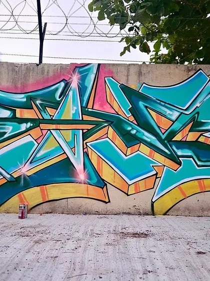 A motion-blur shot of me walking past my finished piece. The dynamic style of the graffiti is matched by the movement in the photo.