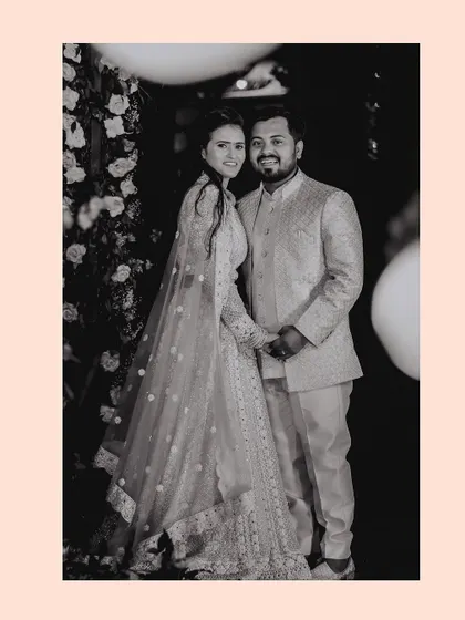A classic black and white portrait of the engaged couple, highlighting their elegant outfits and happy smiles.