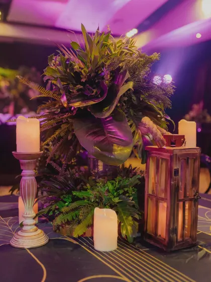 Our team carefully places a lush tropical centerpiece on a table, adding the final touches to the decor.