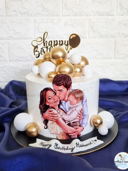A heartwarming cake featuring an edible illustration of the family. This is a beautiful way to celebrate a husband and father, surrounded by gold and white spheres for an elegant touch.