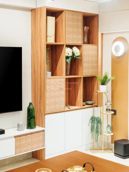 A detailed shot of the custom shelving unit, showcasing a blend of open and closed storage with woven rattan panels, perfect for displaying decor while keeping clutter hidden.