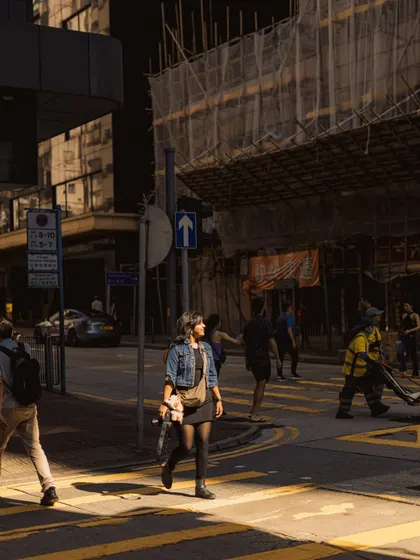 Another perspective of a Hong Kong street scene. The strong contrast between the sunlit patch and the surrounding shadows creates a dramatic, high-impact image.
