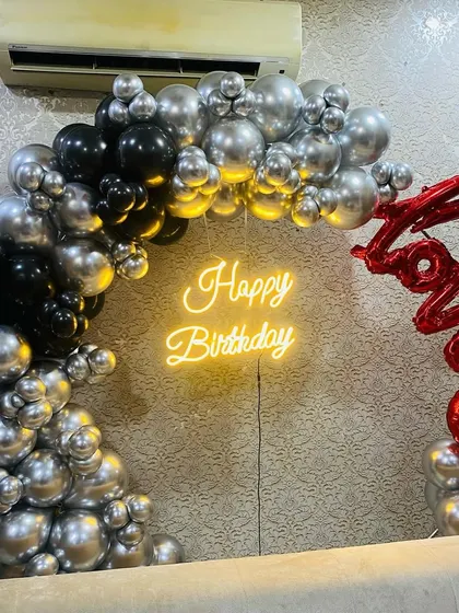 A sophisticated birthday balloon arch in black and silver, with a red "Love" foil balloon accent.
