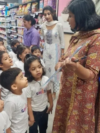 Children listen attentively as their teacher gives instructions for their shopping task. These trips are carefully planned to be safe, educational, and fun.