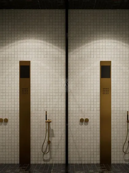 The master shower design for our Kolkata project, featuring minimalist brass fixtures against a backdrop of simple white mosaic tiles for a clean, luxurious look.