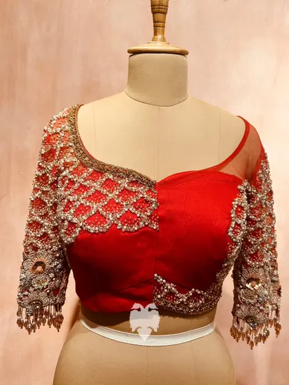 A vision in sheer net, this red blouse is exquisitely hand-embroidered with beads and shimmering katdana in a beautiful lattice pattern.