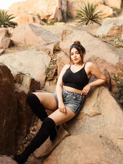 A wider shot from the Aravalli hills session, showing more of the rocky landscape. The composition places the subject within her environment, creating a strong sense of place.