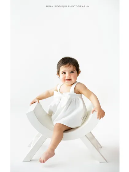 Another angle from Saira's sitter session, showing her confident and happy personality. The clean, high key lighting is a signature of my baby portrait photography style.
