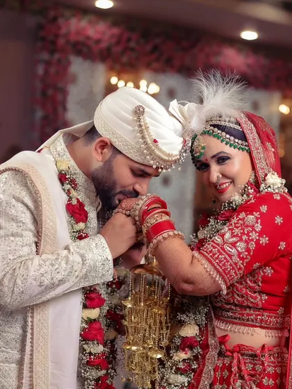 A chivalrous moment as the groom kisses the bride's hand, a gesture of love and respect.