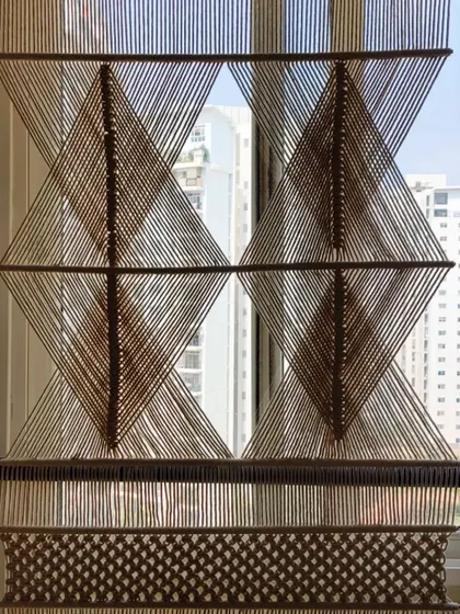 Another section of the macrame partition, highlighting the diamond pattern.