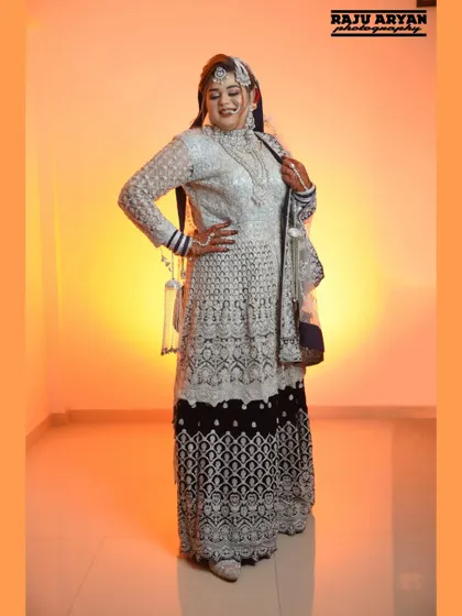 A full-length shot displaying the bride's entire magnificent outfit. This pose shows off the intricate details of her lehenga and her confident stance on her special day.