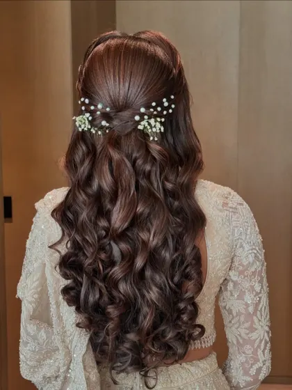 A perfect half-up, half-down hairstyle with beautiful curls and delicate floral accessories. This is a go-to look for modern brides and bridesmaids.