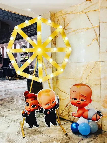 Props for a "Boss Baby" party, including character standees and a light-up Ferris wheel.