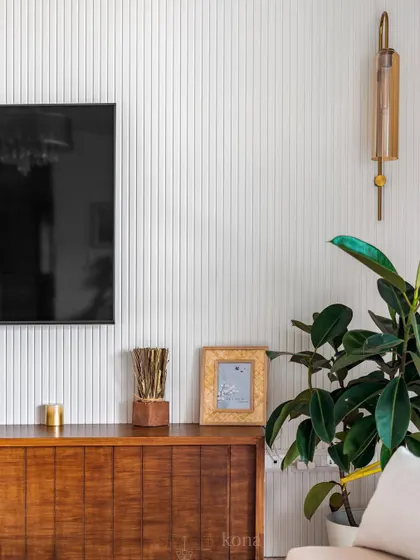 When less is more. This simple TV unit with a fluted wall panel and a clean wooden console creates a clutter-free and stylish entertainment corner.