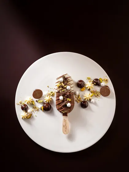 Another gourmet presentation of a Magnum bar, combining different textures and shapes to create a visually interesting and premium dessert plate.