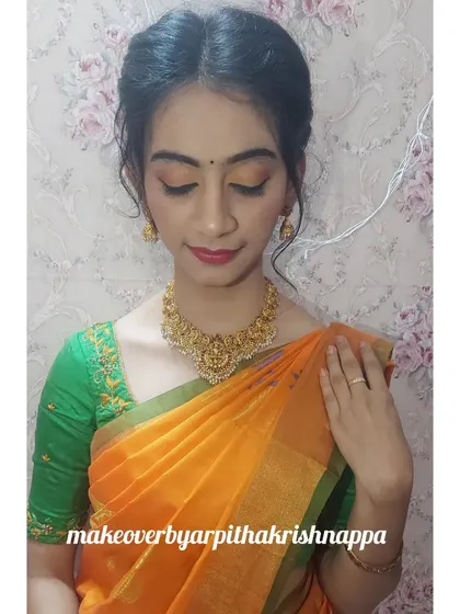 This client wanted a simple and elegant look for a family function. I used warm, earthy tones on the eyes and a classic red lip to complement her beautiful orange and green saree.