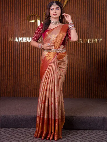 A model in a beige and red silk saree. This is a classic combination, and the drape is styled to look elegant and sophisticated for a reception or formal event.