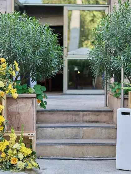 A beautiful entrance detail with rustic wooden crates used as pedestals for lush arrangements of yellow flowers.