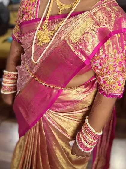 Draped in tradition and adorned with grace. This beautiful pink and gold silk saree is draped to perfection, ready for a wedding reception or major family function.