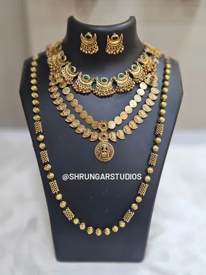 A traditional layered set featuring a unique crescent necklace, a coin haar, and a long beaded mala.
