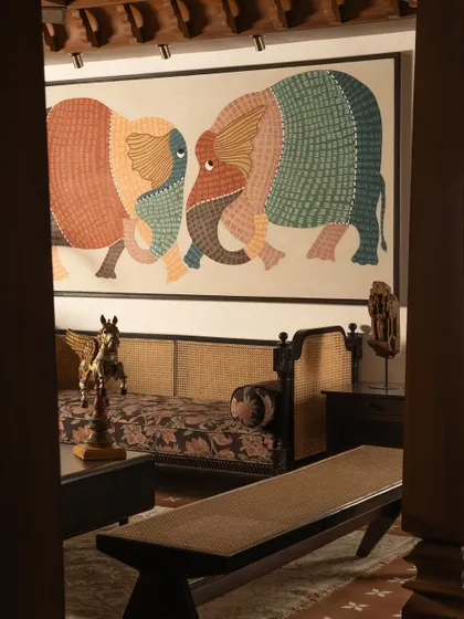 Another view of the living space, framed by the strong vertical lines of the Chettinad pillars. The composition demonstrates a balance between heavy, traditional elements and a light, modern sensibility.