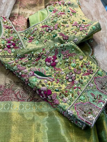 This blouse is a garden in full bloom, crafted with delicate 3D floral embroidery and beadwork. The pastel green fabric is adorned with colorful birds and flowers, creating a piece that is both royal and whimsical.
