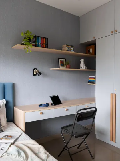 A wider view of the kid's room, showing the complete integrated unit of the bed, desk, and wardrobe, all designed to maximize space and functionality.