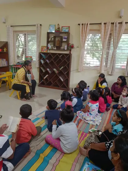 The storyteller's thoughtful expression as she reads shows her own love for the stories she shares.