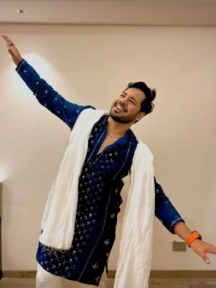 A joyful, expressive pose in the blue kurta. This captures the dynamic energy I bring to the stage.