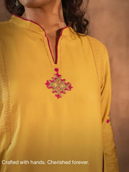 Crafted with hands, cherished forever. This close-up of the neckline on our yellow Ruhani kurta highlights the delicate embroidery, a reminder that true craft takes time and is meant to be treasured.