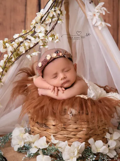 A little flower in her cozy floral tent. The combination of the rustic wooden background and the delicate white blossoms creates a beautiful boho-chic vibe.