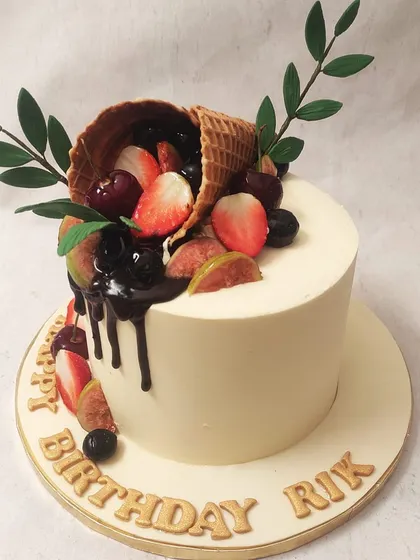 We celebrate nature's sweetness with this fresh fruit cornucopia cake. A waffle cone overflows with fresh strawberries, cherries, and figs, drizzled with rich chocolate, creating a vibrant and delicious design that is both rustic and elegant.