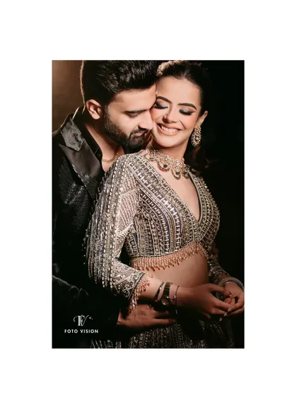 A warm embrace, capturing the love and happiness of the couple. The lighting emphasizes the intricate details of the bride's stunning, embellished gown.