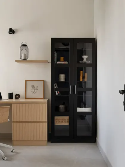 A direct view of the Japandi-style home office, showcasing the balance between the black storage cabinet and the light wood desk.