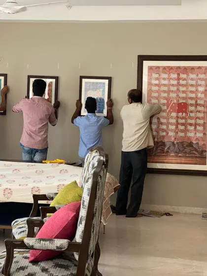 The installation process for my commissioned Pichwai paper works. It takes a team to carefully hang a set of five artworks to ensure they are perfectly aligned and create the intended visual impact.