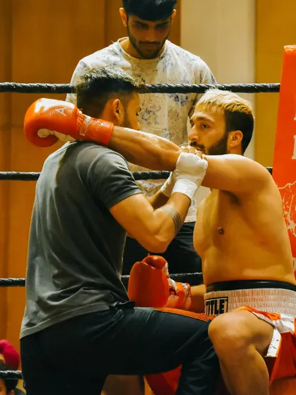 A coach providing support and instructions to a fighter in the corner. This is a critical part of the fight.