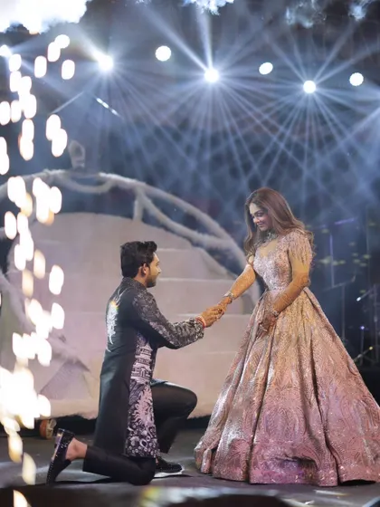 A romantic proposal moment on their reception stage. Surrounded by sparklers, the groom gets down on one knee, creating a truly cinematic and unforgettable memory.