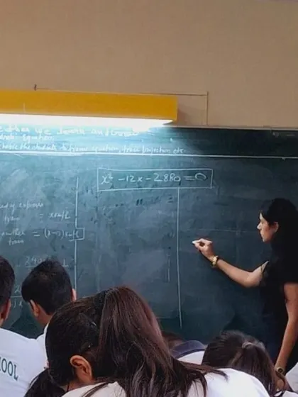 Writing on a chalkboard in a high school math class at a DPS school. I often model lessons directly with students to demonstrate teaching strategies in a real-world context.