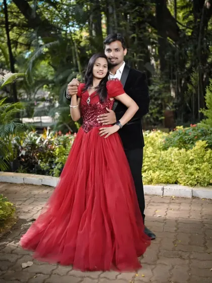 A classic couple portrait in a beautiful garden. The bride's red ball gown with a sequined bodice adds a touch of glamour to their pre-wedding photoshoot.
