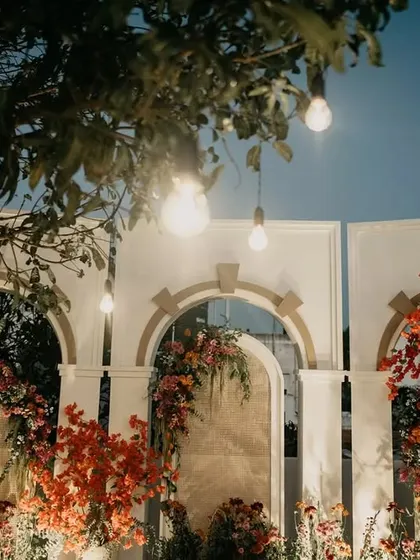 As dusk settled, the ceremony space took on a magical glow. The hanging bulbs and warm floral tones created an incredibly romantic setting for the evening pheras.