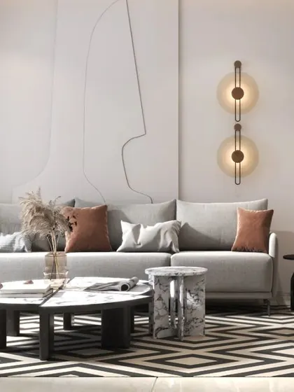 A chic living room with a geometric-patterned rug and line-art wall detail. Pops of terracotta and brown add warmth to the neutral base.