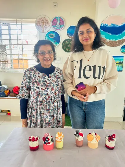 A mother and daughter proudly showing the dessert candles they made together in our workshop. It's a wonderful activity for family members to bond and create side-by-side.