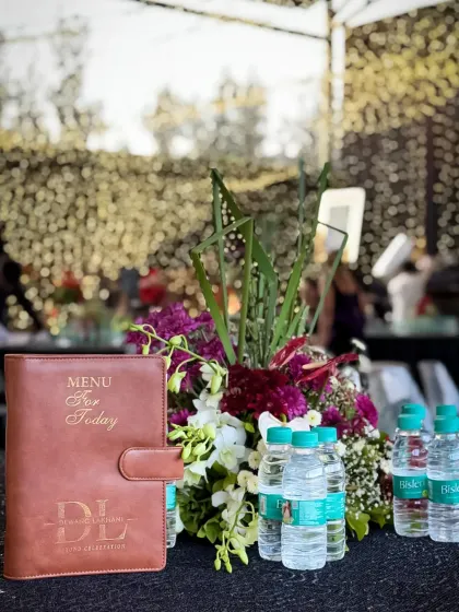 Our custom leather-bound menu, placed next to a beautiful floral arrangement. This detail showcases the premium, bespoke experience we offer our clients from the very beginning.
