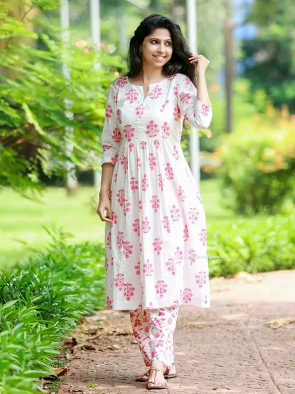Elevate your style with this elegant white and pink printed kurta pant set. The flared kurta can also be worn as a dress, and it has pockets for convenience.