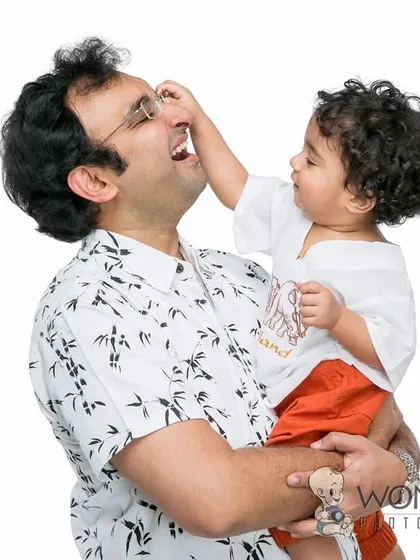 A playful and tender moment between a father and his baby. The baby gently touches his dad's nose, creating a sweet and funny memory that will be cherished for years.
